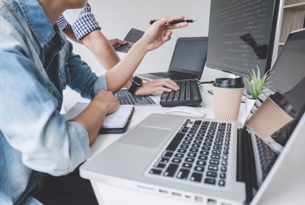 Programmers cooperating at Developing programming and website working in a software develop company office, writing codes and typing data code.